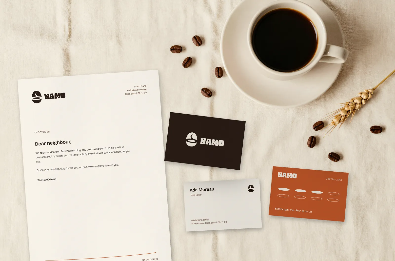 NAMO letterhead, business cards and loyalty card beside a cup of coffee